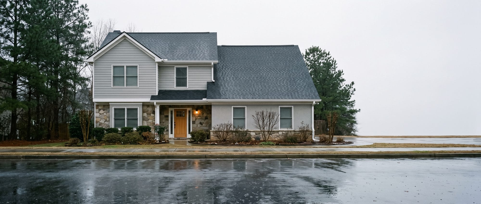 A finished suburban house with a new roof, photographed from across a quiet street.